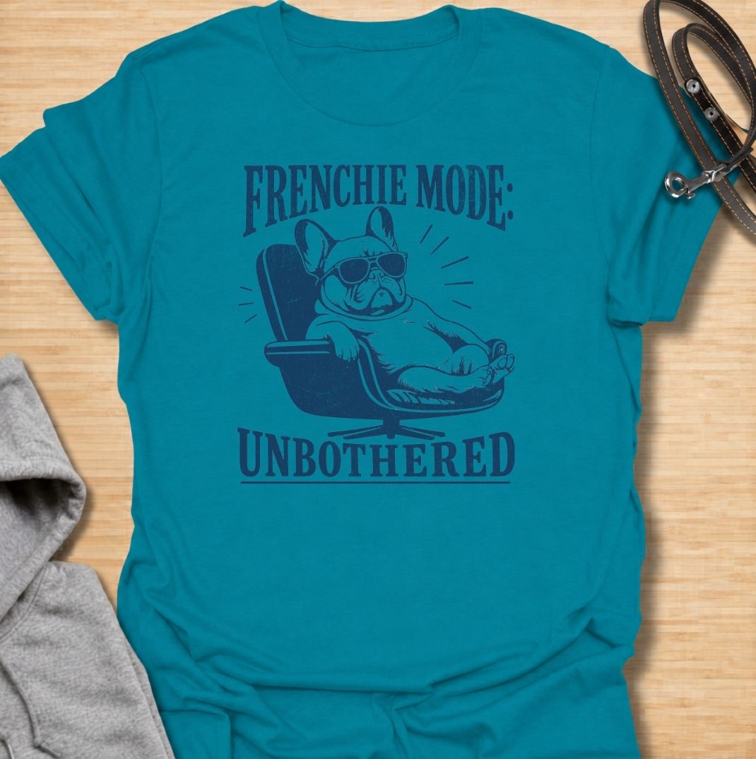 A funny French Bulldog T-shirt for anyone who knows a Frenchie can look completely relaxed while ignoring everything around them. Featuring the phrase “Frenchie Mode: Unbothered” with a laid-back bulldog illustration, this design captures the breed’s cool, stubborn personality perfectly. Ideal for Frenchie moms, Frenchie dads, bulldog lovers, and anyone who appreciates a dog with attitude. A playful everyday tee for fans of French Bulldog humor, relaxed dog vibes, and breed-specific gifts.