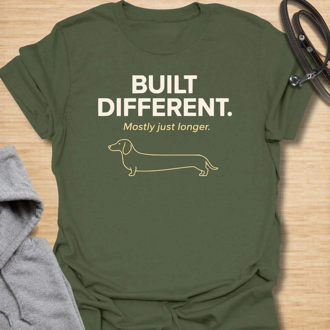 This Built Different Mostly Just Longer t-shirt is made for dachshund lovers who know their little long dog has a body shape like no other. Featuring clean bold typography, a minimal dachshund line illustration, and a funny breed-specific punchline, this design has a simple modern dog-parent feel that doxie owners will instantly understand. Perfect for dachshund moms, dachshund dads, wiener dog fans, rescue dog lovers, and anyone who loves a tiny-legged dog with a very long personality.