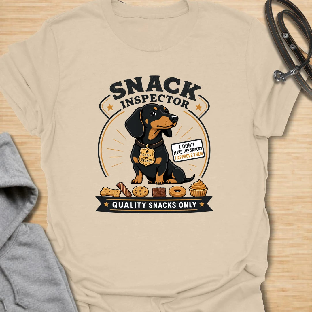 Snack Inspector Dachshund t-shirt for the doxie who takes food quality very seriously. This funny vintage-style design features a dachshund snack inspector with bold badge-style lettering and playful snack details. A perfect gift for dachshund owners whose dog appears the second food is opened. Great for wiener dog lovers, sausage dog fans, and anyone living with a professional crumb detective.