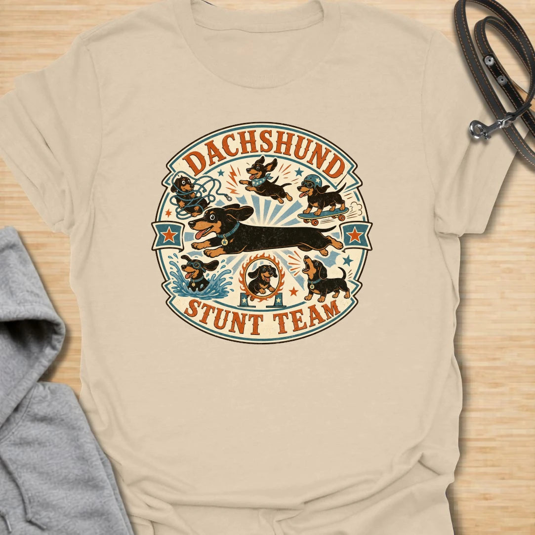 Dachshund Stunt Team t-shirt for sausage dog lovers who know dachshunds treat everyday life like an extreme sport. This vintage circus-style design features adventurous doxies jumping, skating, splashing, barking, and causing chaos. Perfect for dachshund moms, doxie dads, and anyone who loves playful wiener dog humor.