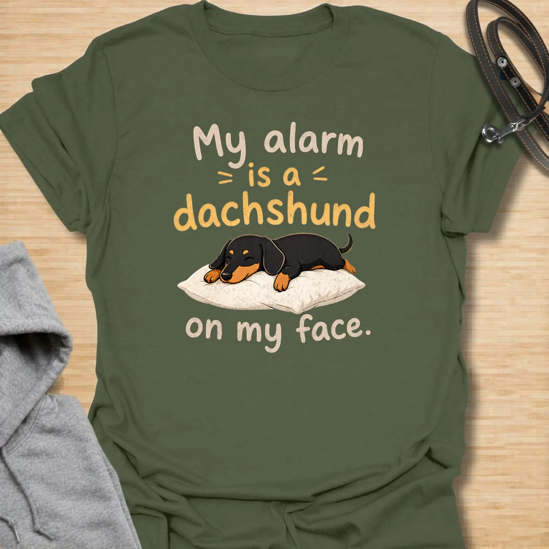This My Alarm Is A Dachshund On My Face t-shirt is made for doxie lovers who know morning wake-up calls are not optional. Featuring a sleepy dachshund stretched across a pillow with playful text, this design has a cute and funny dog-parent feel. Perfect for dachshund moms, dachshund dads, wiener dog fans, rescue dog lovers, and anyone whose little long dog starts the day by climbing on their face.