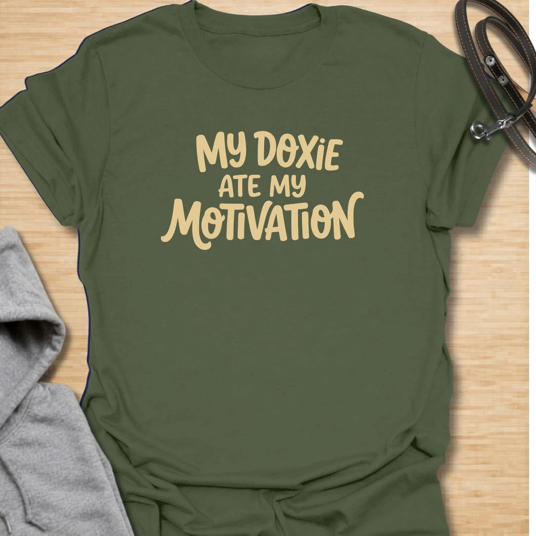 Doxie Motivation t-shirt for dachshund lovers who blame their sausage dog for every lazy day, missed chore, and cozy nap. The playful text reads “My Doxie Ate My Motivation,” making it a funny choice for doxie moms, dog owners, and anyone whose dachshund runs the household. A relatable gift for dog people with a lazy little sidekick.