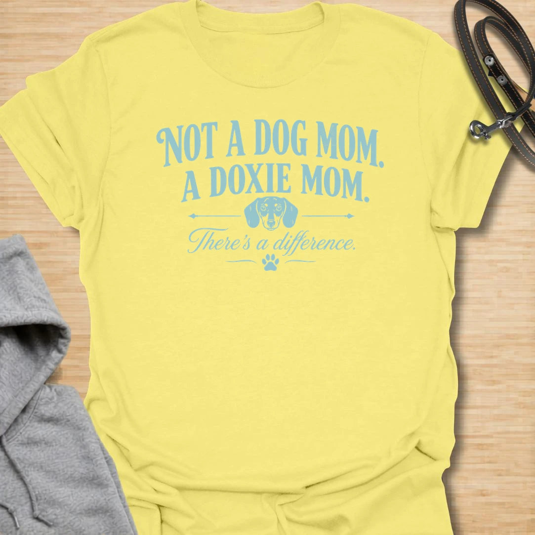 This Not A Dog Mom A Doxie Mom t-shirt is made for dachshund lovers who know there is definitely a difference. Featuring vintage-style typography, a small dachshund accent, paw print details, and a funny breed-specific message, this design has a simple dog-parent feel that doxie owners will instantly understand. Perfect for dachshund moms, wiener dog fans, sausage dog lovers, rescue dog owners, and anyone proudly living the doxie mom life.