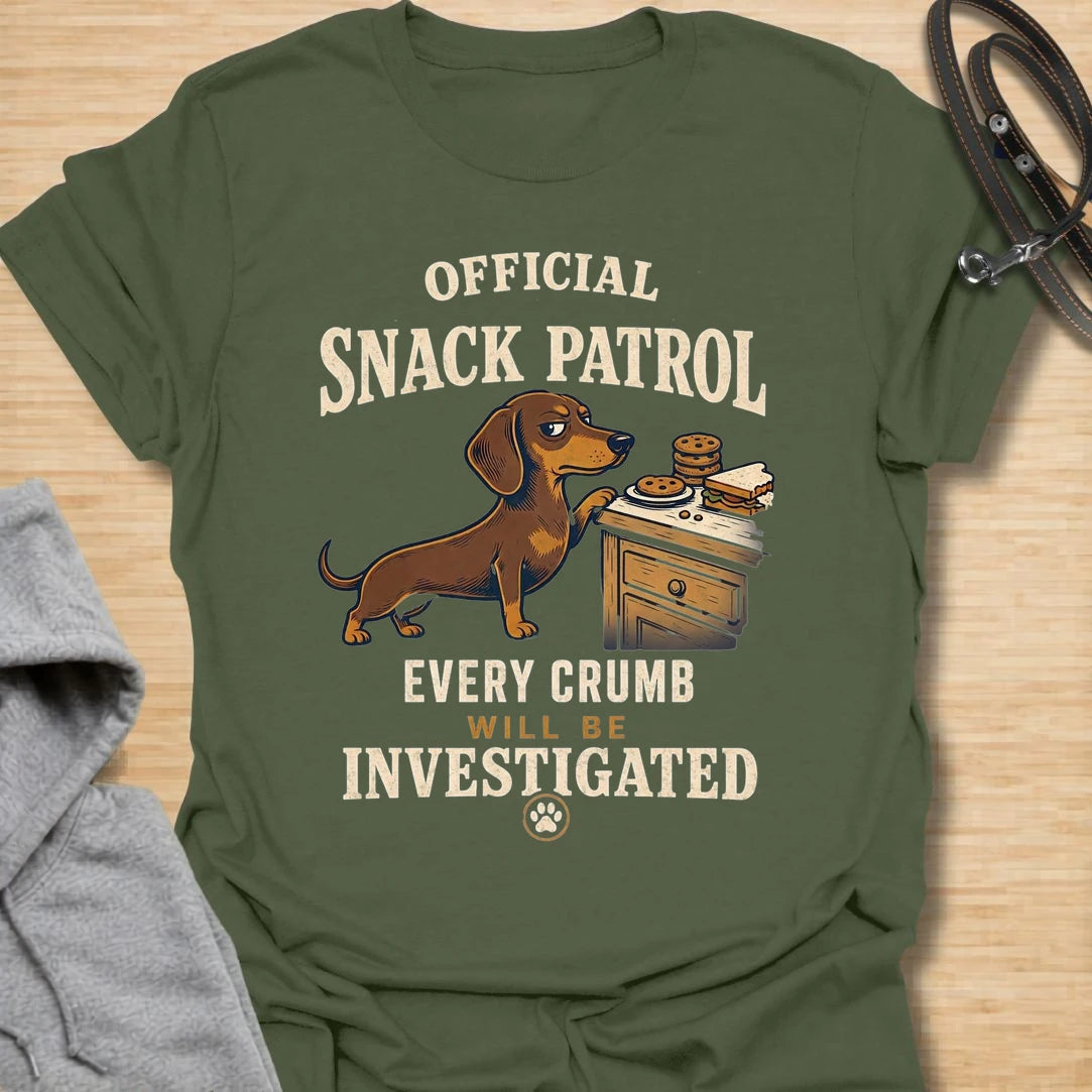This Official Snack Patrol t-shirt is made for dachshund lovers who know no crumb, snack, or unattended plate is ever truly safe. Featuring a determined doxie investigating a bedside table full of treats with bold vintage-style text, this funny dog design is great for dachshund moms, dachshund dads, wiener dog fans, rescue dog lovers, and anyone whose little long dog takes snack supervision very seriously.