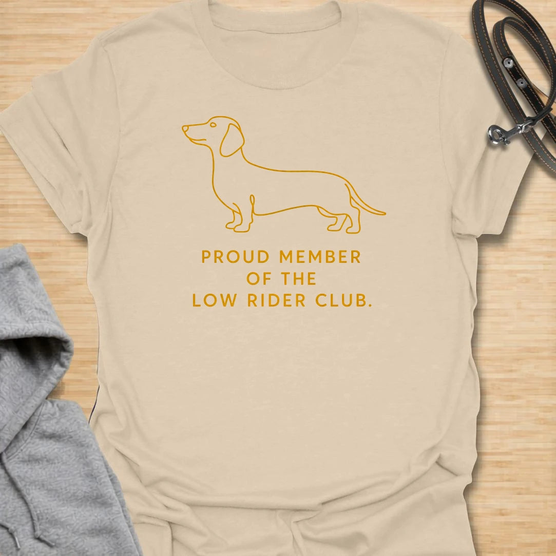 This Proud Member Of The Low Rider Club t-shirt is made for dachshund lovers who celebrate tiny legs, long bodies, and big personality. Featuring a simple dachshund line illustration with bold club-style lettering, this design has a clean, classic dog-parent feel. Perfect for dachshund moms, dachshund dads, wiener dog fans, rescue dog lovers, and anyone proudly part of the low rider club.