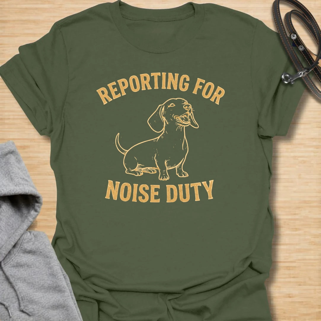 This Reporting For Noise Duty t-shirt is made for dachshund lovers who know their little long dog takes barking very seriously. Featuring a bold one-color dachshund illustration with strong simple lettering, this design has a funny breed-specific feel that doxie owners will instantly understand. Perfect for dachshund moms, dachshund dads, wiener dog fans, rescue dog lovers, and anyone living with a tiny self-appointed alarm system.
