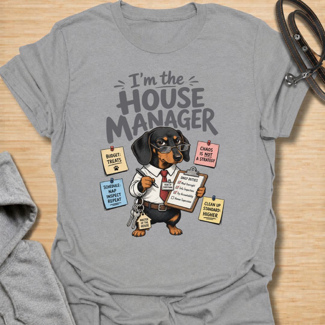 Celebrate life with a bossy little sausage dog in this funny “I’m the House Manager” dachshund T-shirt. Featuring a determined doxie managing treats, naps, household duties, and general chaos, it is perfect for dachshund moms, dog dads, and wiener dog lovers. A playful gift for anyone whose dachshund clearly runs the home.