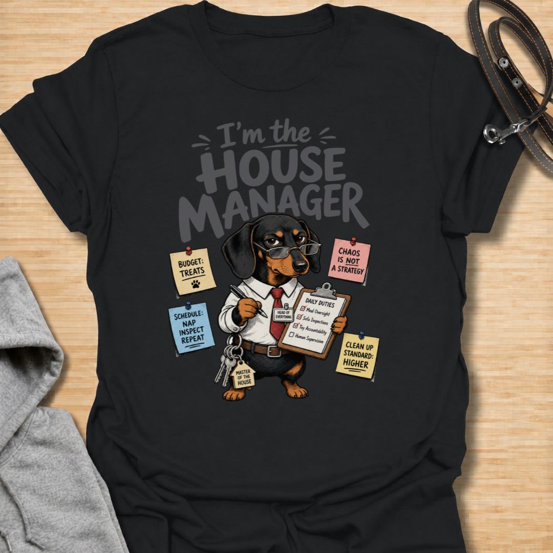 Celebrate life with a bossy little sausage dog in this funny “I’m the House Manager” dachshund T-shirt. Featuring a determined doxie managing treats, naps, household duties, and general chaos, it is perfect for dachshund moms, dog dads, and wiener dog lovers. A playful gift for anyone whose dachshund clearly runs the home.