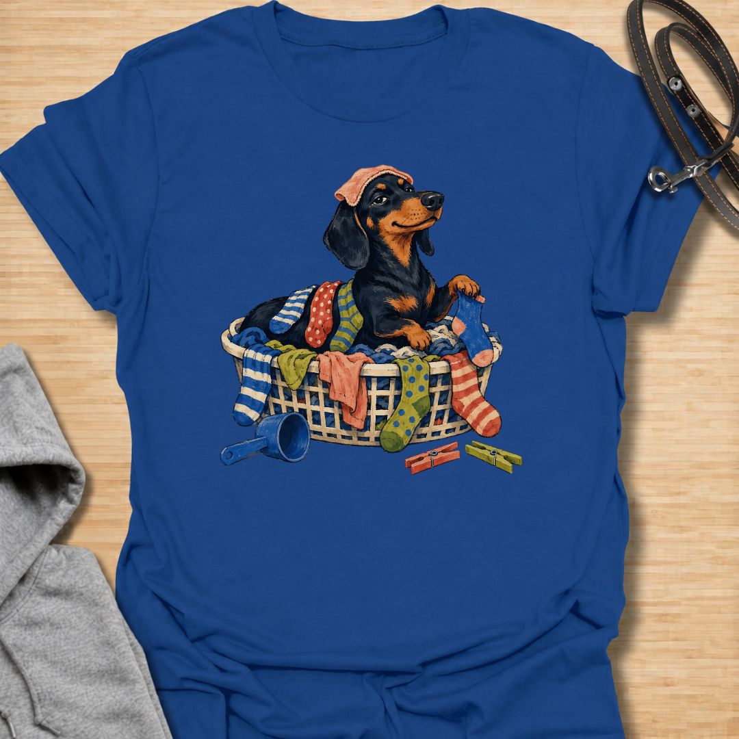 Bring a little dachshund mischief to laundry day with this playful sausage dog T-shirt. Featuring a proud doxie sitting in a basket overflowing with colorful clothes, it is perfect for dachshund moms, dog dads, and anyone whose pet insists on helping with household chores. A fun gift for wiener dog lovers who know that clean laundry is really just another dog bed.