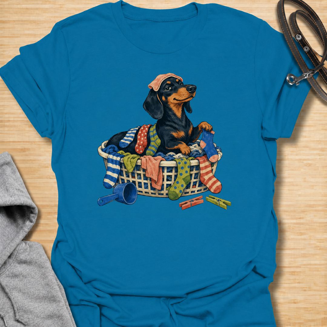 Bring a little dachshund mischief to laundry day with this playful sausage dog T-shirt. Featuring a proud doxie sitting in a basket overflowing with colorful clothes, it is perfect for dachshund moms, dog dads, and anyone whose pet insists on helping with household chores. A fun gift for wiener dog lovers who know that clean laundry is really just another dog bed.