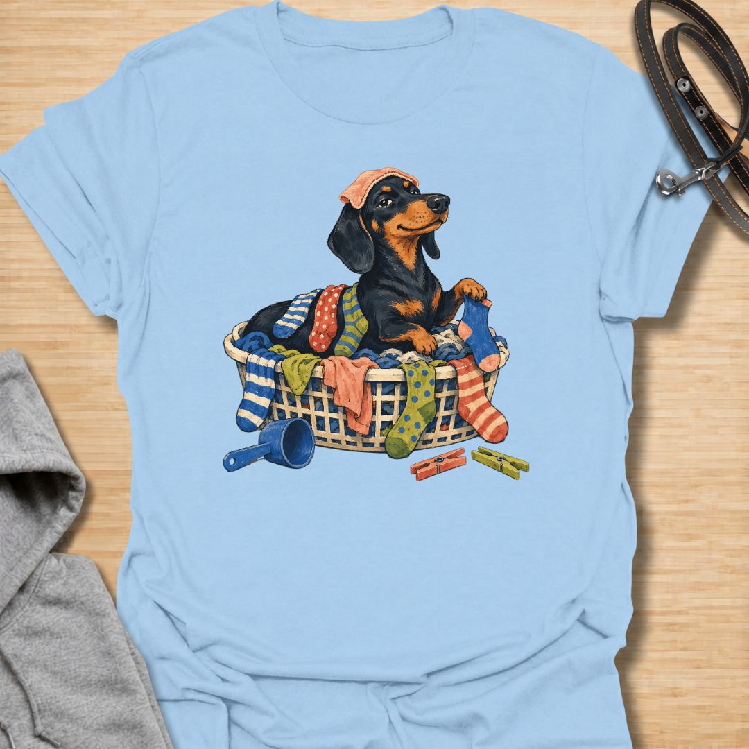 Bring a little dachshund mischief to laundry day with this playful sausage dog T-shirt. Featuring a proud doxie sitting in a basket overflowing with colorful clothes, it is perfect for dachshund moms, dog dads, and anyone whose pet insists on helping with household chores. A fun gift for wiener dog lovers who know that clean laundry is really just another dog bed.