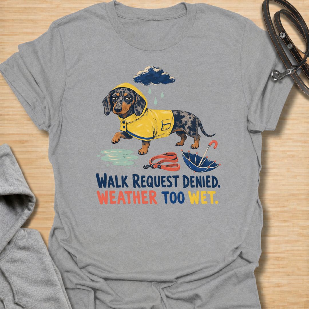 Celebrate a dachshund’s selective approach to outdoor adventures with this funny “Walk Request Denied, Weather Too Wet” T-shirt. Featuring a raincoat-wearing doxie beside a puddle, umbrella, and leash, it is perfect for dachshund moms, dog dads, and sausage dog lovers. A playful gift for anyone whose stubborn little dog refuses to walk in the rain.