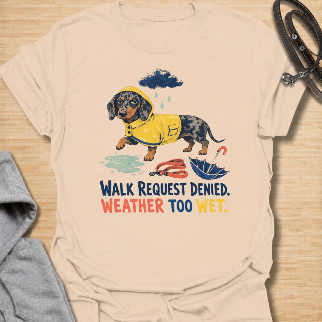 Celebrate a dachshund’s selective approach to outdoor adventures with this funny “Walk Request Denied, Weather Too Wet” T-shirt. Featuring a raincoat-wearing doxie beside a puddle, umbrella, and leash, it is perfect for dachshund moms, dog dads, and sausage dog lovers. A playful gift for anyone whose stubborn little dog refuses to walk in the rain.