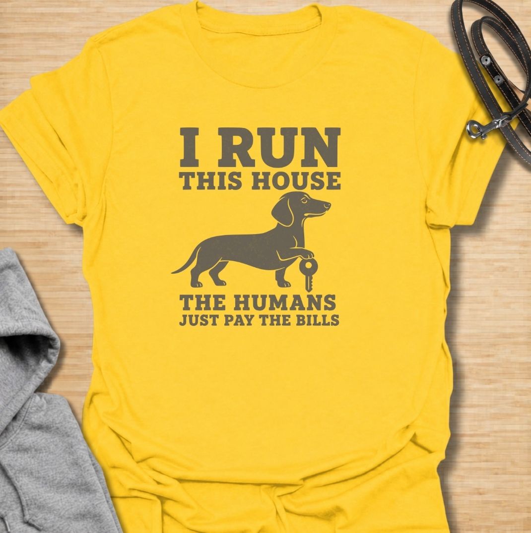 I run this house—the humans just pay the bills. A funny dachshund T-shirt for owners whose confident sausage dog is clearly in charge.