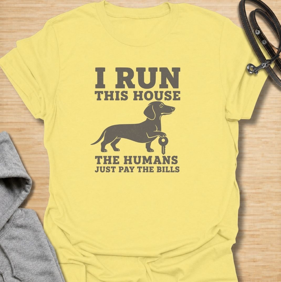 I run this house—the humans just pay the bills. A funny dachshund T-shirt for owners whose confident sausage dog is clearly in charge.