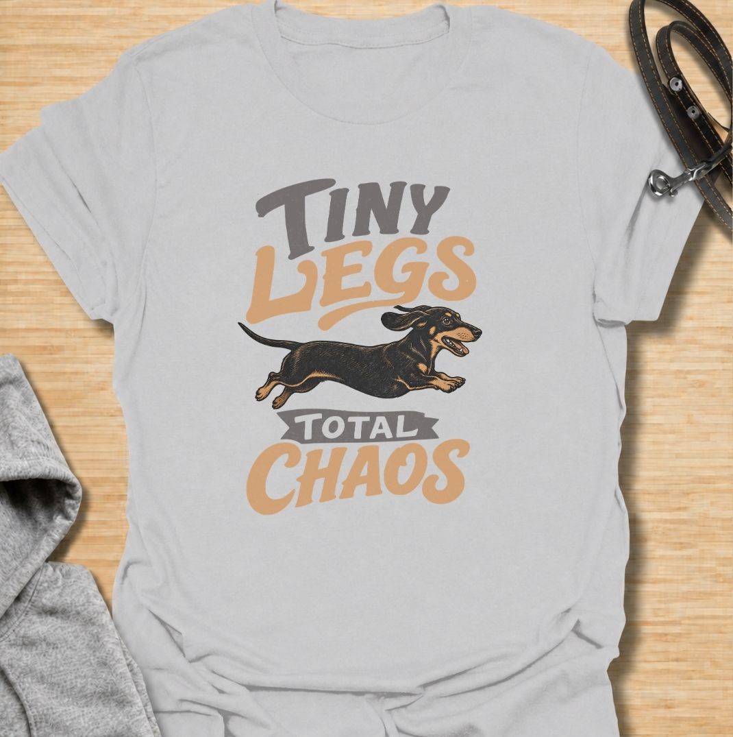 Tiny legs, total chaos. A funny dachshund T-shirt for sausage dog owners who know those short legs can create trouble at remarkable speed.