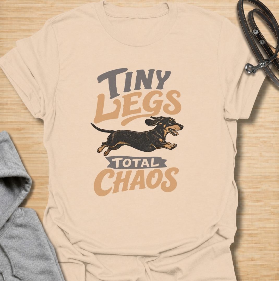 Tiny legs, total chaos. A funny dachshund T-shirt for sausage dog owners who know those short legs can create trouble at remarkable speed.