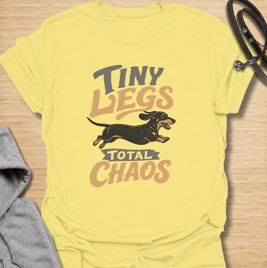 Tiny legs, total chaos. A funny dachshund T-shirt for sausage dog owners who know those short legs can create trouble at remarkable speed.