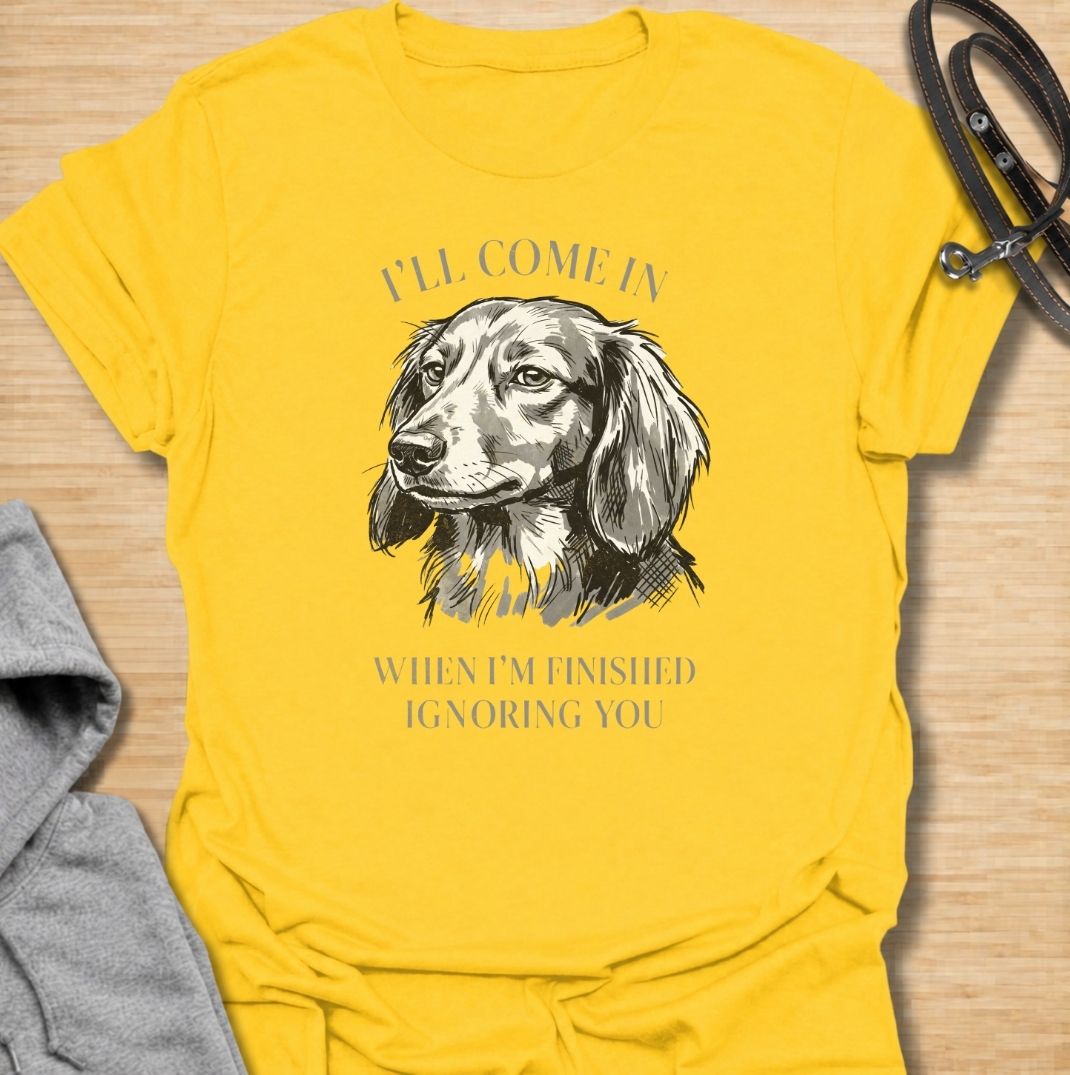 I’ll come in when I’m finished ignoring you. A funny dachshund T-shirt for owners who know recall is always optional when a doxie has other plans.