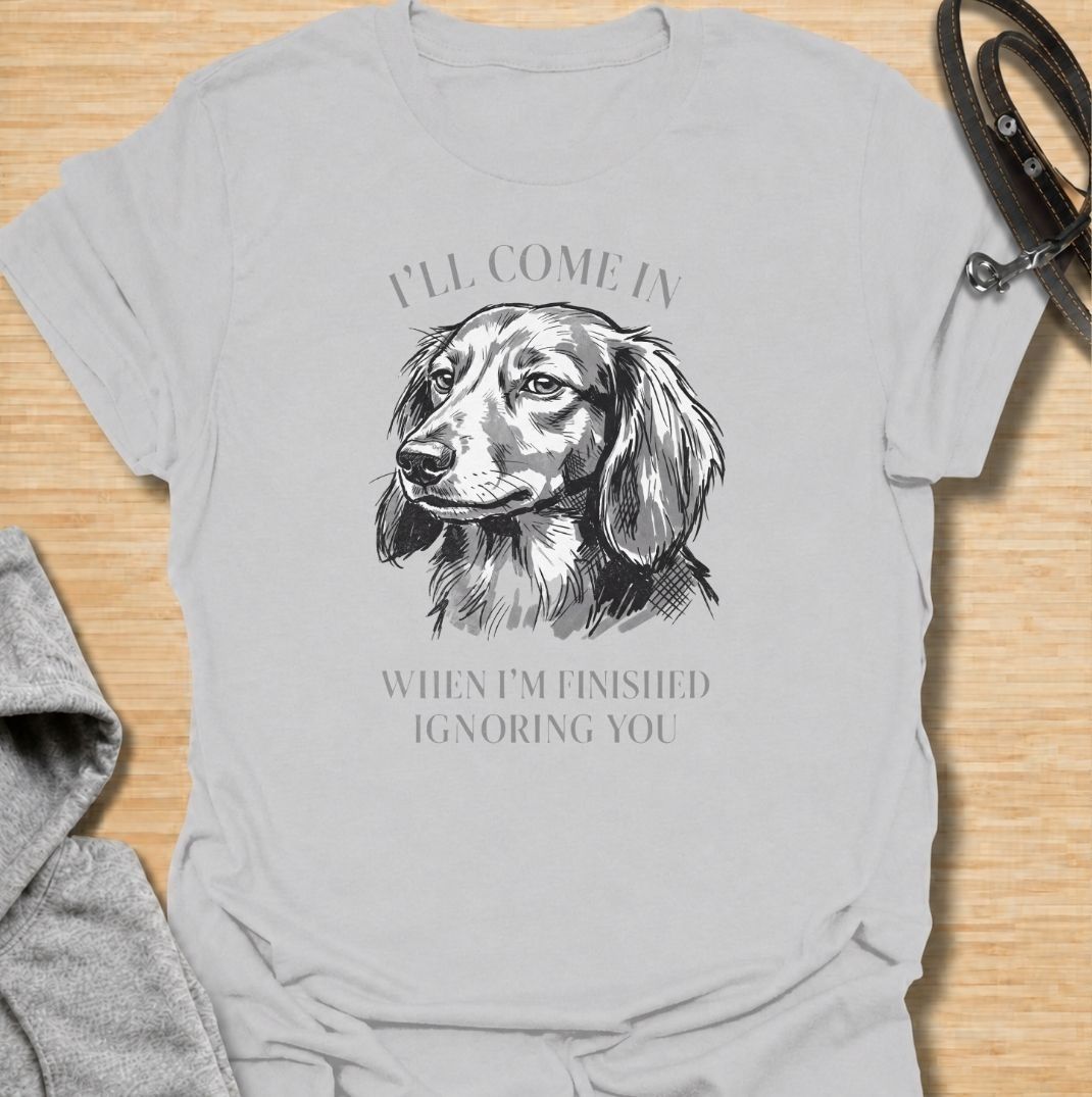 I’ll come in when I’m finished ignoring you. A funny dachshund T-shirt for owners who know recall is always optional when a doxie has other plans.
