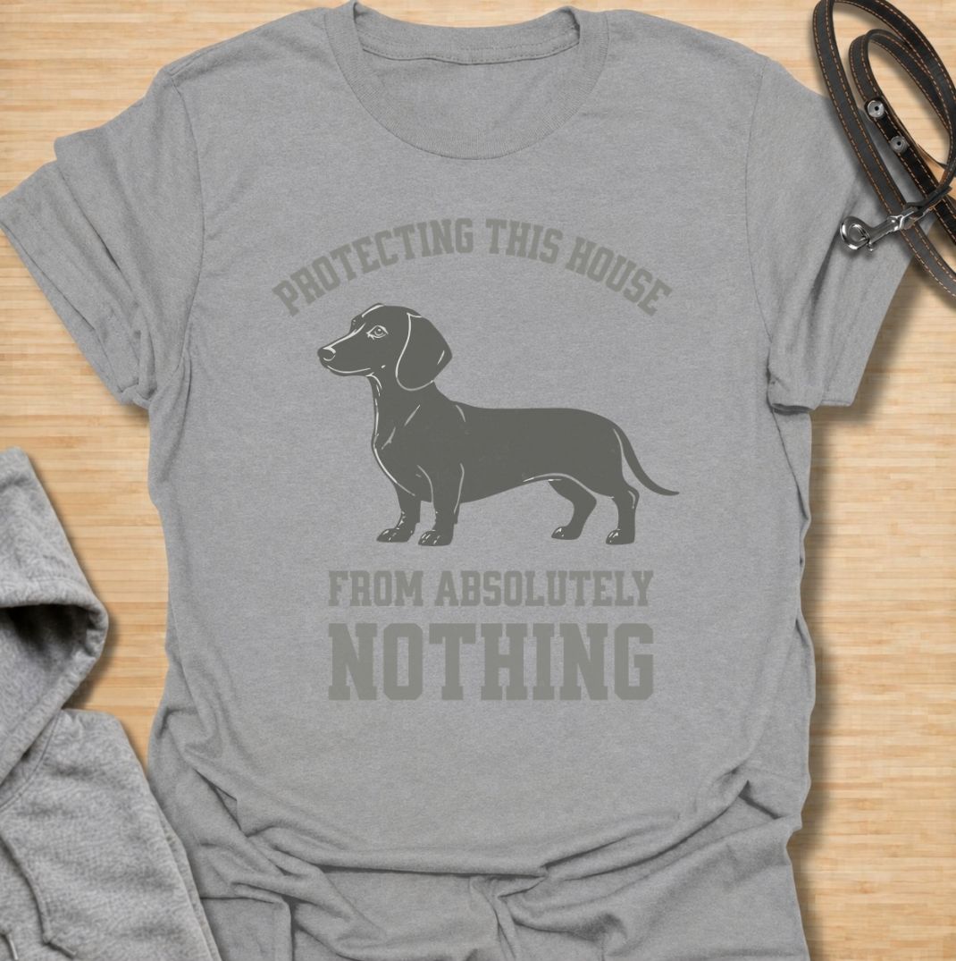 Protecting this house from absolutely nothing. A funny dachshund T-shirt for sausage dog owners who know their little watchdog takes security very seriously.