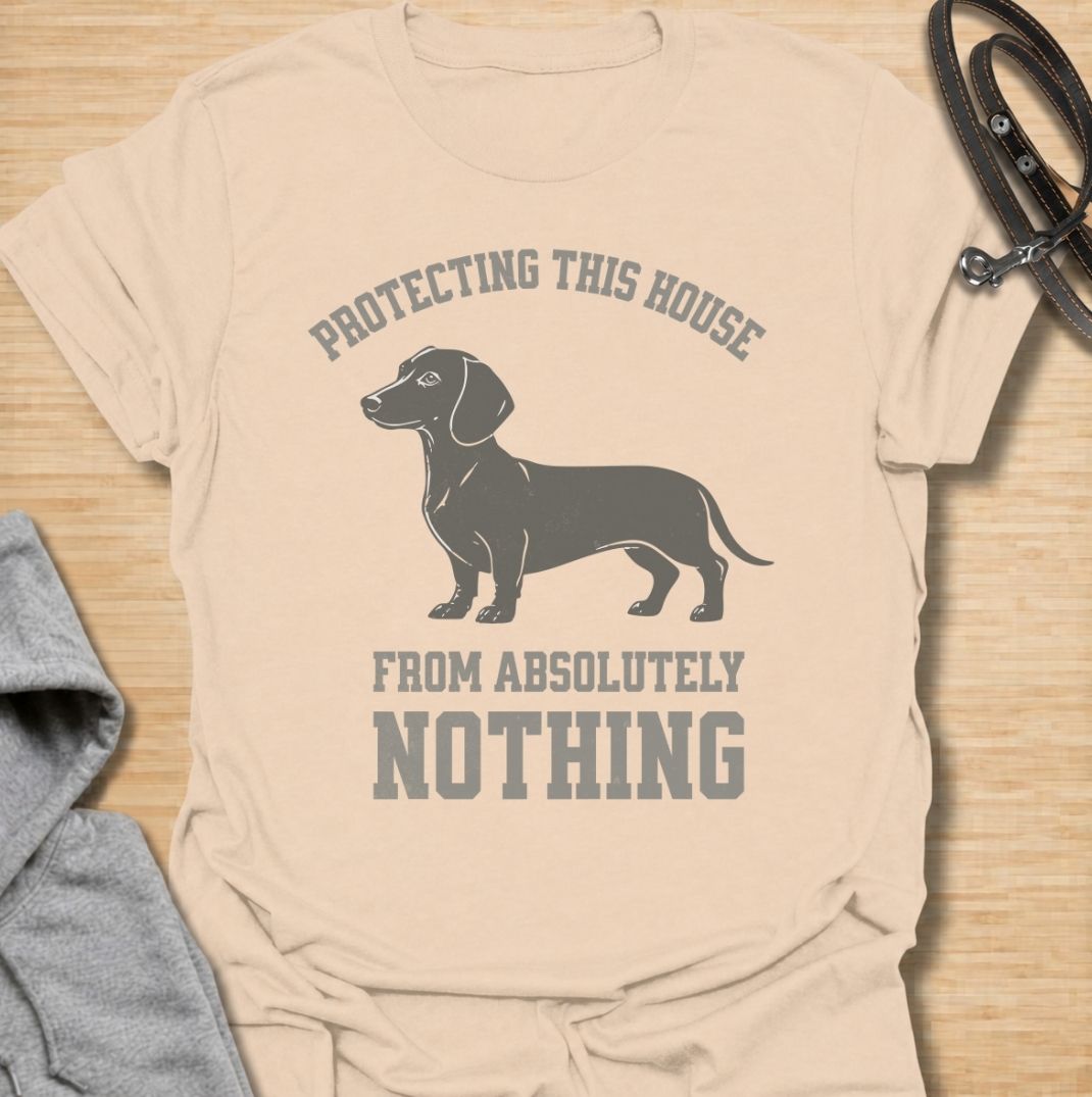 Protecting this house from absolutely nothing. A funny dachshund T-shirt for sausage dog owners who know their little watchdog takes security very seriously.