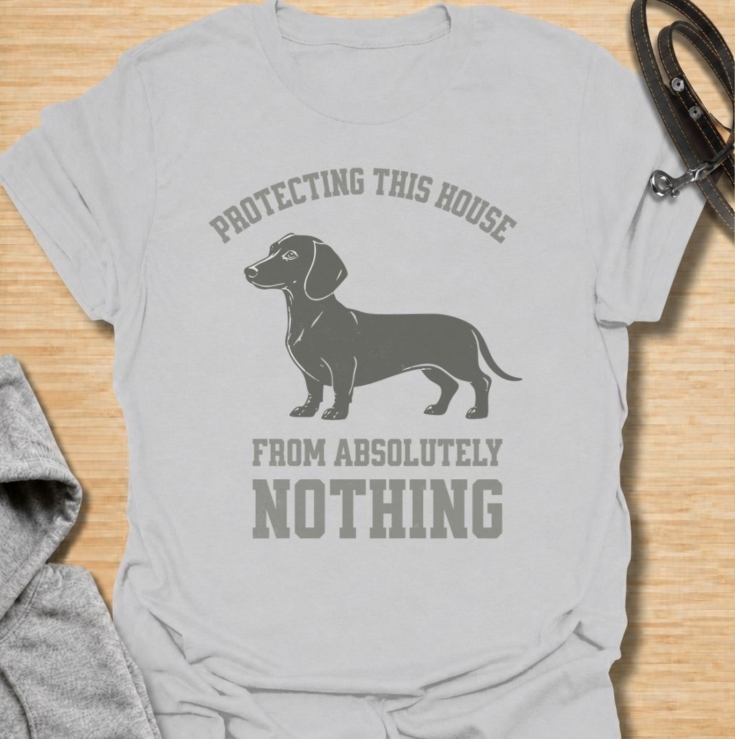 Protecting this house from absolutely nothing. A funny dachshund T-shirt for sausage dog owners who know their little watchdog takes security very seriously.