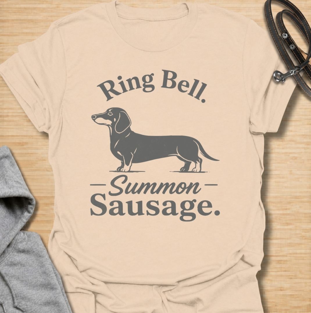 Ring bell, summon sausage. A funny dachshund T-shirt for sausage dog owners who know the doorbell instantly activates their little household alarm.