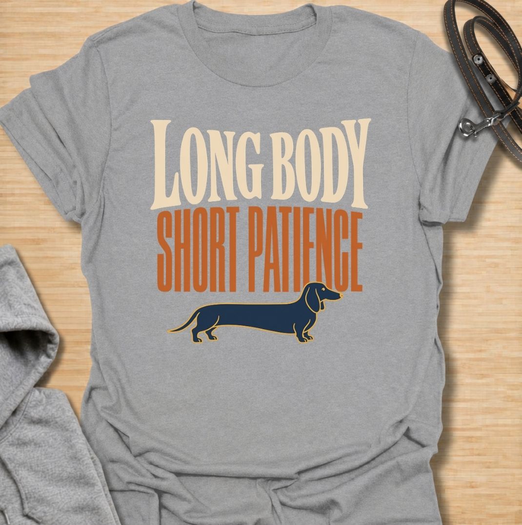 For dachshunds blessed with an impressively long body and a remarkably limited supply of patience. This funny dachshund T-shirt features the phrase “Long Body, Short Patience” with a clean vintage-inspired sausage dog illustration. Perfect for doxie owners who know stubbornness, impatience and plenty of attitude all come with those tiny legs. A bold dog lover tee that captures classic dachshund personality without taking itself too seriously.