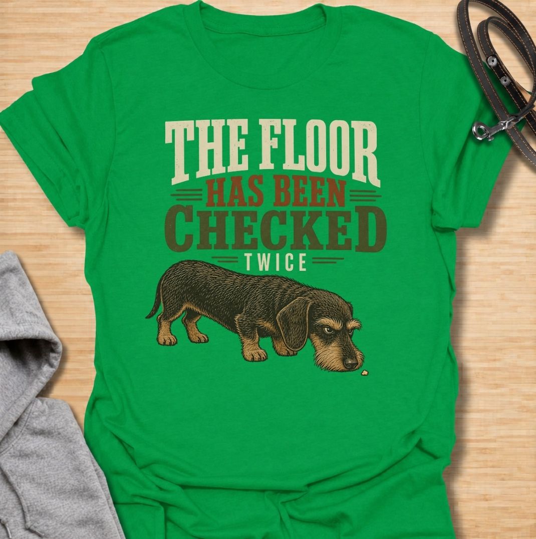 For dachshunds who treat every dropped crumb like an urgent inspection assignment. This funny dachshund T-shirt features the phrase “The Floor Has Been Checked Twice” with a determined little doxie on snack patrol. Perfect for dog owners who know their sausage dog never misses a food-related opportunity. A playful vintage-style dog lover tee that captures classic dachshund greed, focus and personality.