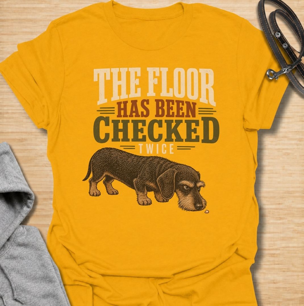 For dachshunds who treat every dropped crumb like an urgent inspection assignment. This funny dachshund T-shirt features the phrase “The Floor Has Been Checked Twice” with a determined little doxie on snack patrol. Perfect for dog owners who know their sausage dog never misses a food-related opportunity. A playful vintage-style dog lover tee that captures classic dachshund greed, focus and personality.
