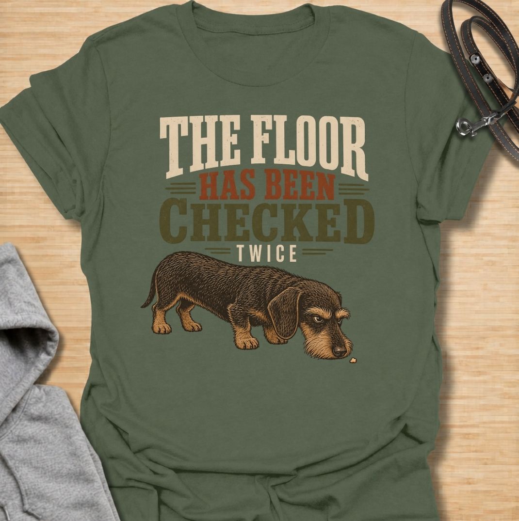 For dachshunds who treat every dropped crumb like an urgent inspection assignment. This funny dachshund T-shirt features the phrase “The Floor Has Been Checked Twice” with a determined little doxie on snack patrol. Perfect for dog owners who know their sausage dog never misses a food-related opportunity. A playful vintage-style dog lover tee that captures classic dachshund greed, focus and personality.