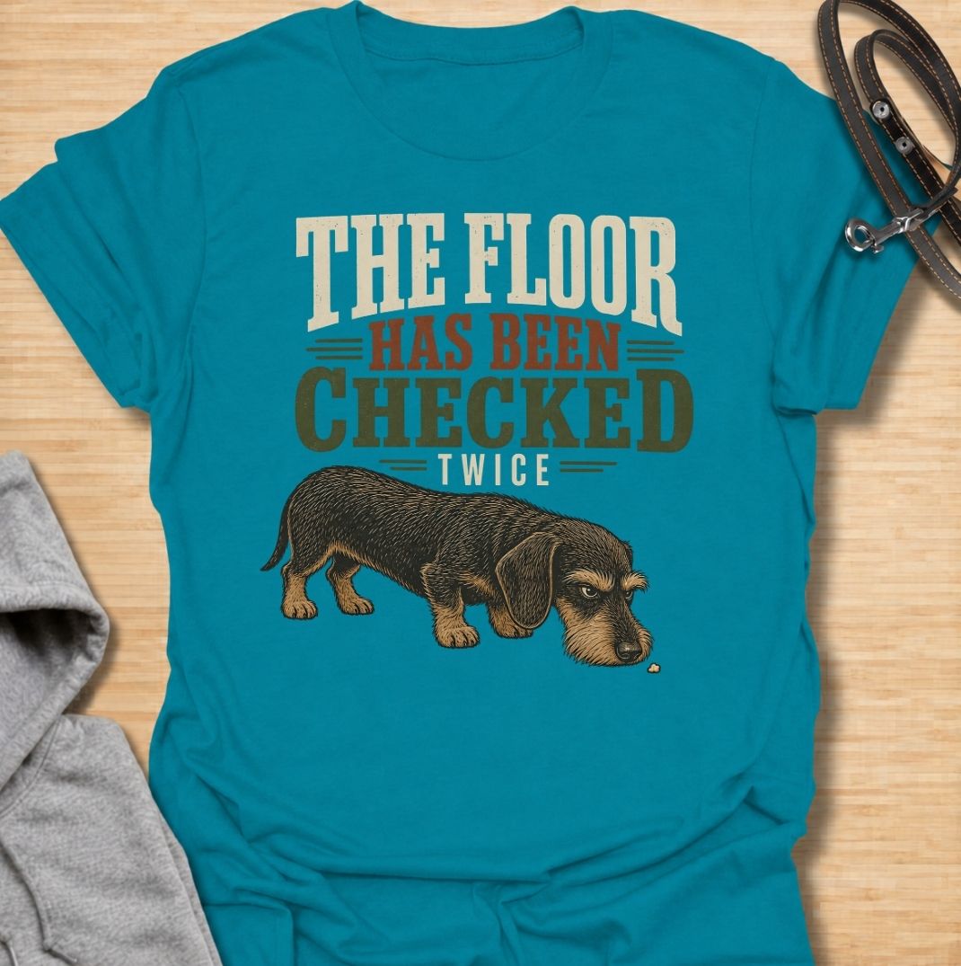For dachshunds who treat every dropped crumb like an urgent inspection assignment. This funny dachshund T-shirt features the phrase “The Floor Has Been Checked Twice” with a determined little doxie on snack patrol. Perfect for dog owners who know their sausage dog never misses a food-related opportunity. A playful vintage-style dog lover tee that captures classic dachshund greed, focus and personality.
