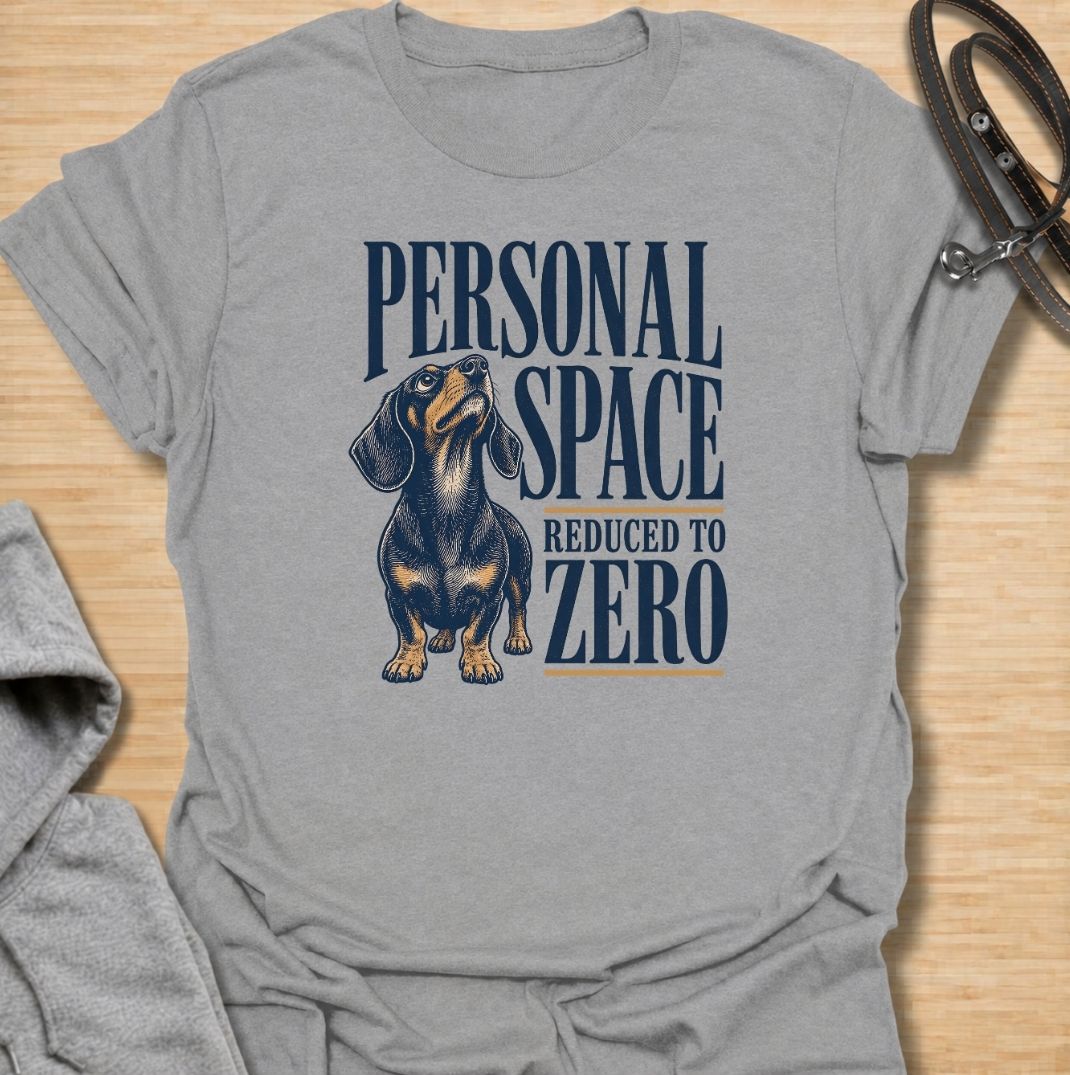 A funny dachshund T-shirt for anyone whose idea of personal space disappeared the moment a dachshund moved in. Featuring the phrase “Personal Space Reduced to Zero” with a bold vintage-style dachshund illustration, this design captures the breed’s famously clingy personality. Perfect for dachshund moms, dachshund dads, sausage dog owners, and anyone who lives with a devoted little shadow. A playful everyday tee for fans of dachshund humor, velcro dogs, and affectionate four-legged companions.