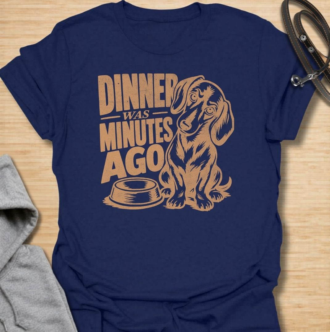 A funny dachshund T-shirt for anyone whose dog believes dinner is always overdue. Featuring the phrase “Dinner Was Minutes Ago” with a hungry-looking dachshund and empty bowl, this design perfectly captures the breed’s dramatic relationship with food. Ideal for dachshund moms, dachshund dads, sausage dog owners, and anyone familiar with the stare that appears five minutes after mealtime. A playful everyday tee for fans of dachshund humor, food-obsessed dogs, and permanently hungry little companions.