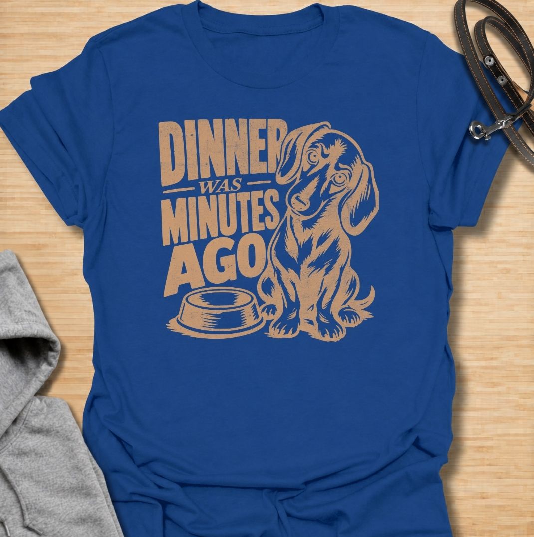 A funny dachshund T-shirt for anyone whose dog believes dinner is always overdue. Featuring the phrase “Dinner Was Minutes Ago” with a hungry-looking dachshund and empty bowl, this design perfectly captures the breed’s dramatic relationship with food. Ideal for dachshund moms, dachshund dads, sausage dog owners, and anyone familiar with the stare that appears five minutes after mealtime. A playful everyday tee for fans of dachshund humor, food-obsessed dogs, and permanently hungry little companions.