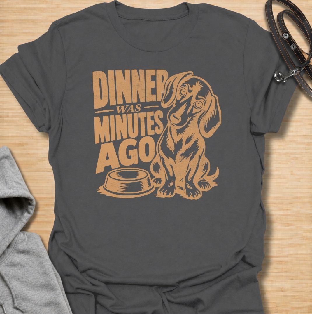 A funny dachshund T-shirt for anyone whose dog believes dinner is always overdue. Featuring the phrase “Dinner Was Minutes Ago” with a hungry-looking dachshund and empty bowl, this design perfectly captures the breed’s dramatic relationship with food. Ideal for dachshund moms, dachshund dads, sausage dog owners, and anyone familiar with the stare that appears five minutes after mealtime. A playful everyday tee for fans of dachshund humor, food-obsessed dogs, and permanently hungry little companions.