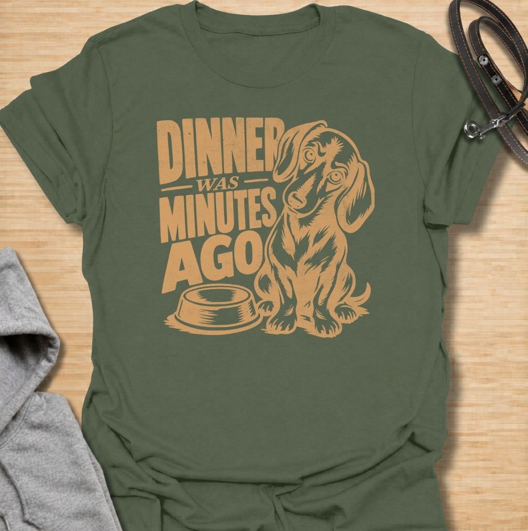 A funny dachshund T-shirt for anyone whose dog believes dinner is always overdue. Featuring the phrase “Dinner Was Minutes Ago” with a hungry-looking dachshund and empty bowl, this design perfectly captures the breed’s dramatic relationship with food. Ideal for dachshund moms, dachshund dads, sausage dog owners, and anyone familiar with the stare that appears five minutes after mealtime. A playful everyday tee for fans of dachshund humor, food-obsessed dogs, and permanently hungry little companions.