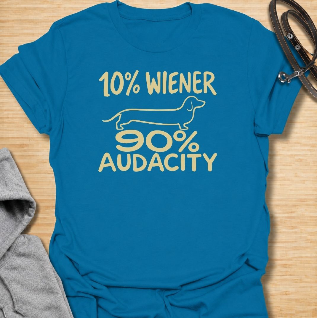 A funny dachshund T-shirt for anyone who knows that being small has absolutely no effect on a dachshund’s confidence. Featuring the phrase “10% Wiener, 90% Audacity” with a simple sausage dog outline, this design captures the breed’s bold, stubborn, larger-than-life personality. Perfect for dachshund moms, dachshund dads, wiener dog owners, and anyone familiar with the attitude packed into those short little legs. A playful everyday tee for fans of dachshund humor, sausage dog jokes, and breed-specific gift