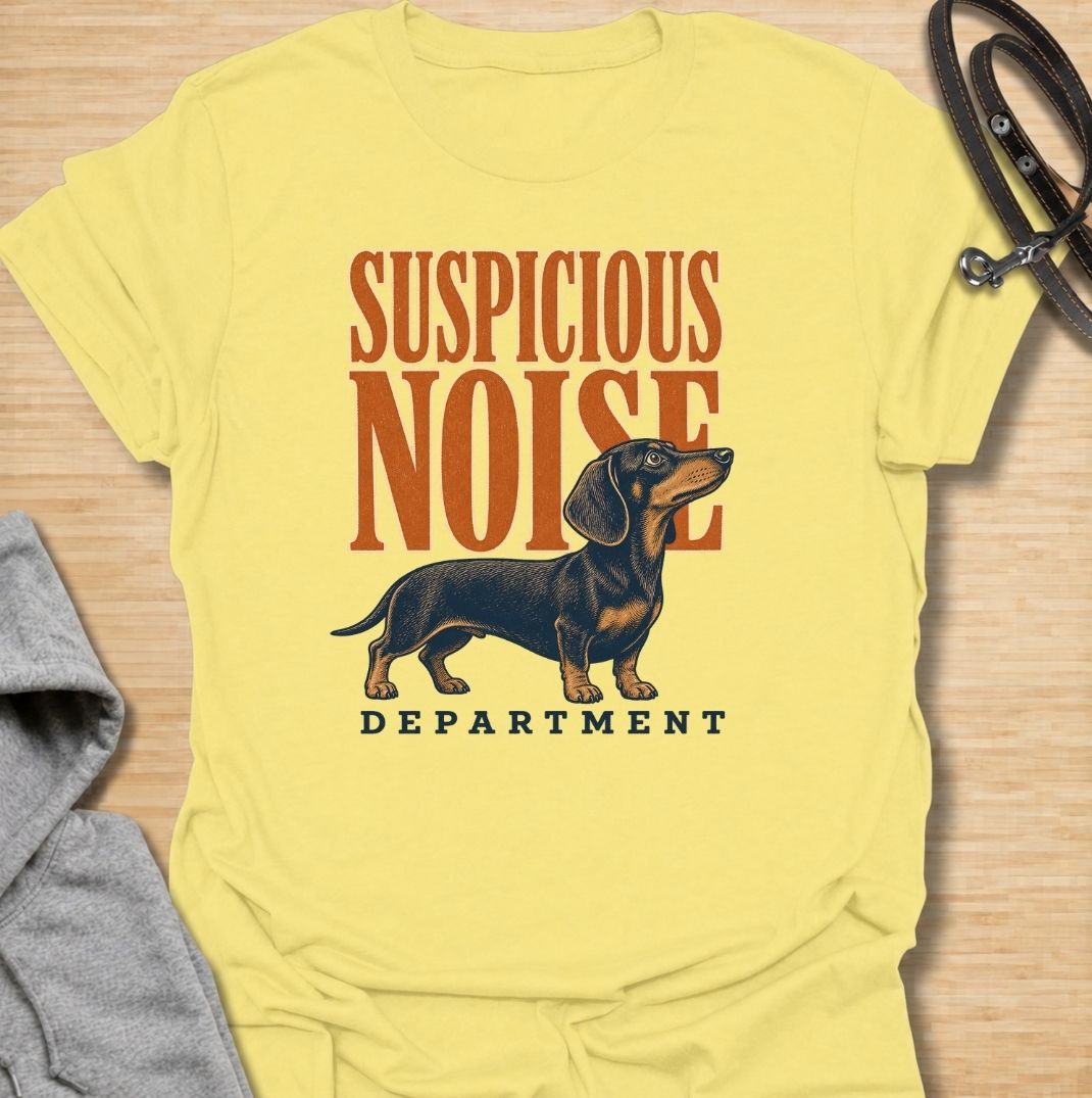 A funny dachshund T-shirt for anyone whose dog treats every unexpected sound like an urgent investigation. Featuring the phrase “Suspicious Noise Department” with a watchful dachshund illustration, this design captures the breed’s alert, curious, and slightly dramatic personality. Perfect for dachshund moms, dachshund dads, sausage dog owners, and anyone familiar with barking at absolutely nothing. A playful everyday tee for fans of dachshund humor, watchdog jokes, and breed-specific dog gifts.
