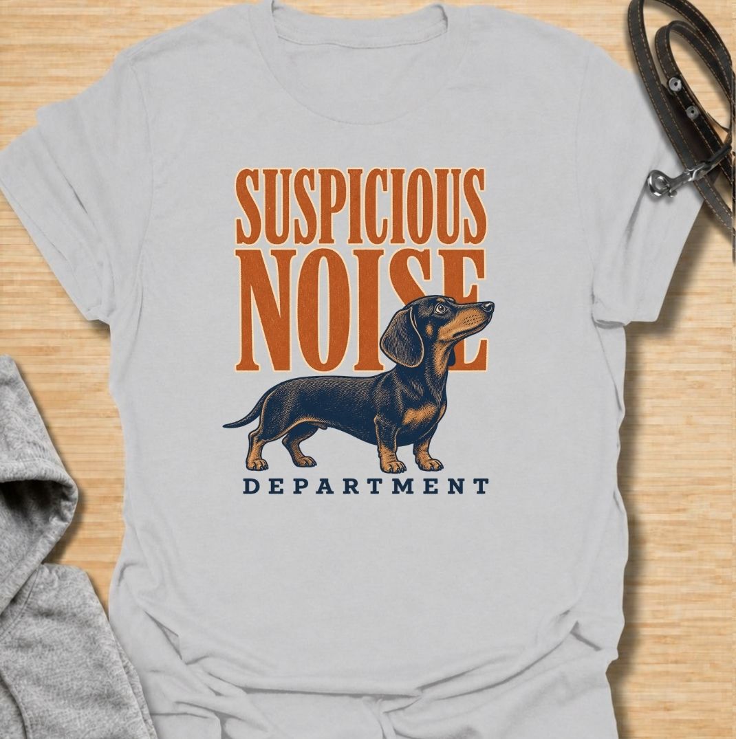 A funny dachshund T-shirt for anyone whose dog treats every unexpected sound like an urgent investigation. Featuring the phrase “Suspicious Noise Department” with a watchful dachshund illustration, this design captures the breed’s alert, curious, and slightly dramatic personality. Perfect for dachshund moms, dachshund dads, sausage dog owners, and anyone familiar with barking at absolutely nothing. A playful everyday tee for fans of dachshund humor, watchdog jokes, and breed-specific dog gifts.