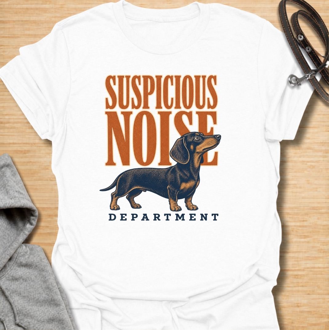 A funny dachshund T-shirt for anyone whose dog treats every unexpected sound like an urgent investigation. Featuring the phrase “Suspicious Noise Department” with a watchful dachshund illustration, this design captures the breed’s alert, curious, and slightly dramatic personality. Perfect for dachshund moms, dachshund dads, sausage dog owners, and anyone familiar with barking at absolutely nothing. A playful everyday tee for fans of dachshund humor, watchdog jokes, and breed-specific dog gifts.
