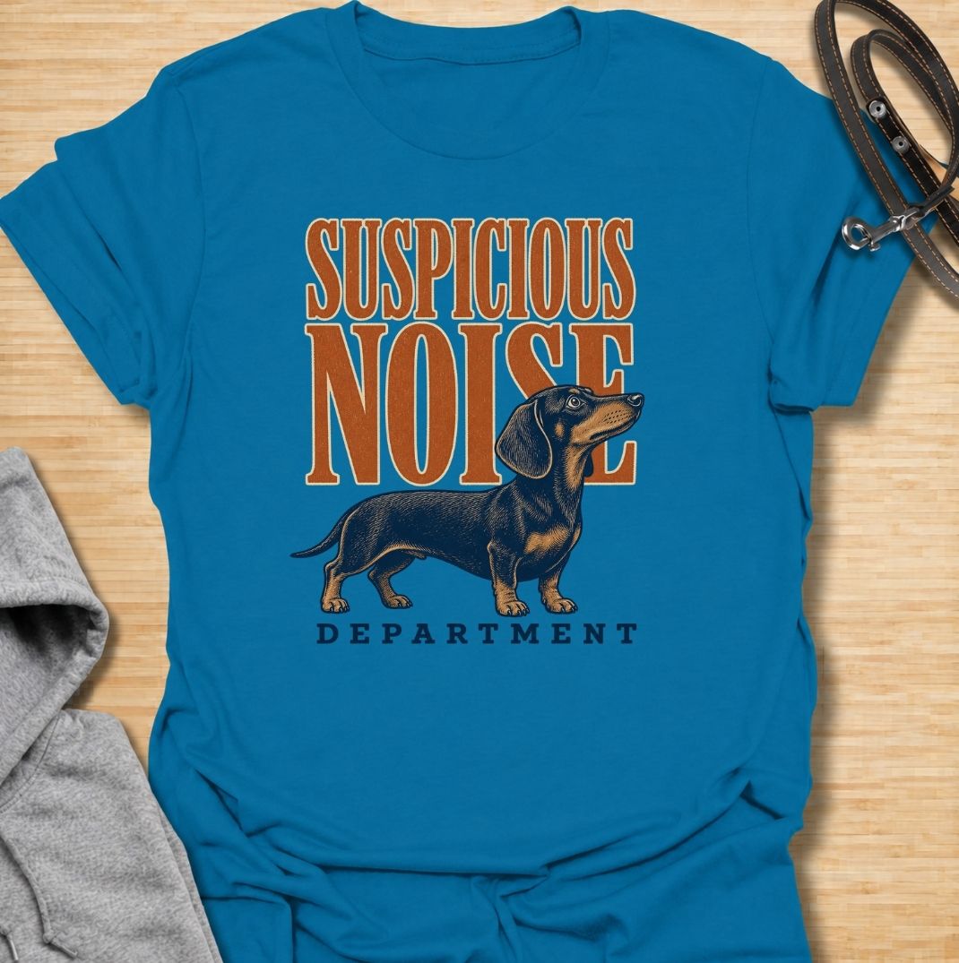 A funny dachshund T-shirt for anyone whose dog treats every unexpected sound like an urgent investigation. Featuring the phrase “Suspicious Noise Department” with a watchful dachshund illustration, this design captures the breed’s alert, curious, and slightly dramatic personality. Perfect for dachshund moms, dachshund dads, sausage dog owners, and anyone familiar with barking at absolutely nothing. A playful everyday tee for fans of dachshund humor, watchdog jokes, and breed-specific dog gifts.