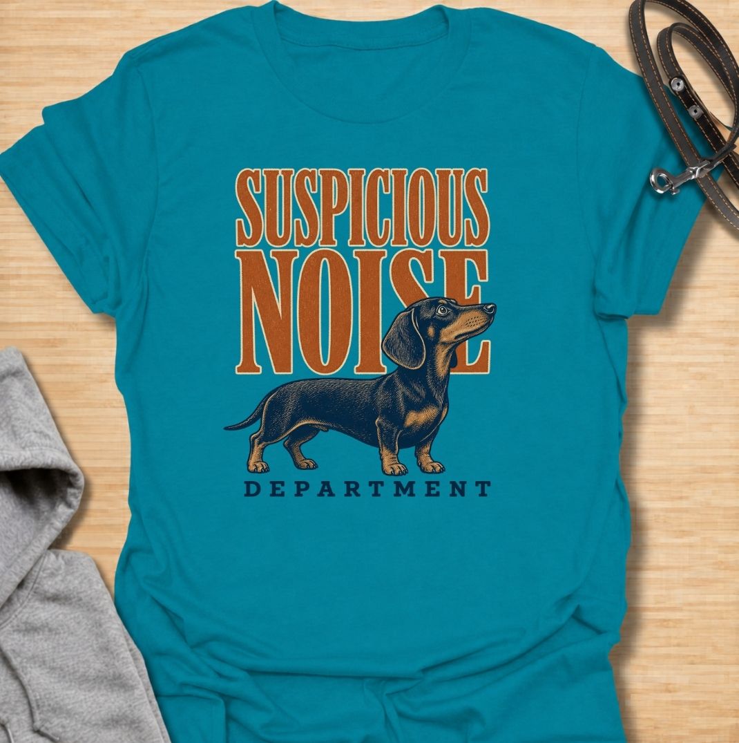 A funny dachshund T-shirt for anyone whose dog treats every unexpected sound like an urgent investigation. Featuring the phrase “Suspicious Noise Department” with a watchful dachshund illustration, this design captures the breed’s alert, curious, and slightly dramatic personality. Perfect for dachshund moms, dachshund dads, sausage dog owners, and anyone familiar with barking at absolutely nothing. A playful everyday tee for fans of dachshund humor, watchdog jokes, and breed-specific dog gifts.