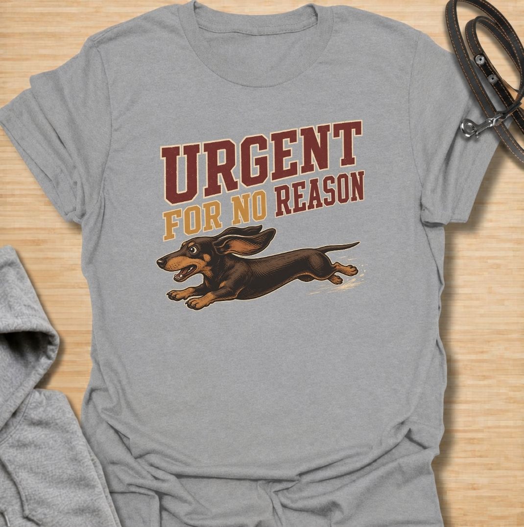 A funny dachshund T-shirt for anyone familiar with the sudden bursts of speed that seem to come from absolutely nowhere. Featuring the phrase “Urgent For No Reason” with a running dachshund illustration, this design captures the breed’s energetic, dramatic personality perfectly. Ideal for dachshund moms, dachshund dads, sausage dog owners, and anyone who has witnessed an unexpected dachshund sprint across the house or yard. A playful everyday tee for fans of dachshund humor, wiener dog chaos, and small dogs