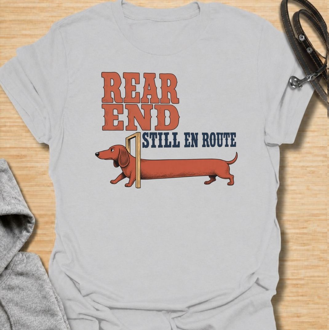 A funny dachshund T-shirt for anyone who knows a sausage dog can seem to arrive in two separate installments. Featuring the phrase “Rear End Still En Route” with a stretched-out dachshund illustration, this design makes the most of the breed’s famously long body. Perfect for dachshund moms, dachshund dads, wiener dog owners, and anyone who loves dry breed-specific humor. A playful everyday tee for fans of dachshunds, sausage dogs, and quirky dog gifts.