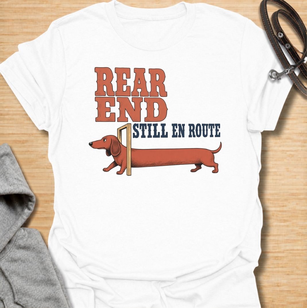 A funny dachshund T-shirt for anyone who knows a sausage dog can seem to arrive in two separate installments. Featuring the phrase “Rear End Still En Route” with a stretched-out dachshund illustration, this design makes the most of the breed’s famously long body. Perfect for dachshund moms, dachshund dads, wiener dog owners, and anyone who loves dry breed-specific humor. A playful everyday tee for fans of dachshunds, sausage dogs, and quirky dog gifts.