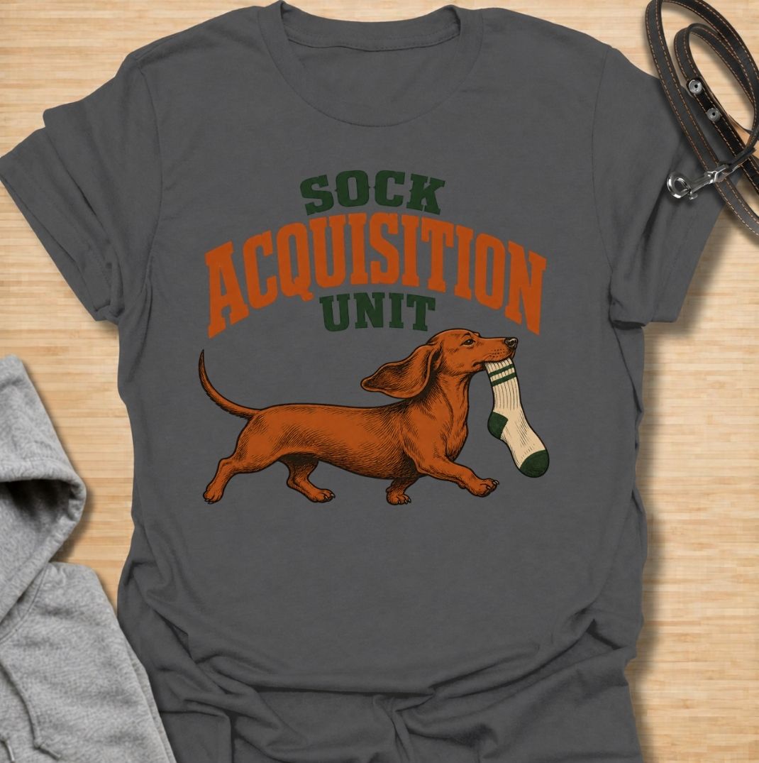 A funny dachshund T-shirt for anyone whose socks mysteriously disappear whenever their dog is nearby. Featuring the phrase “Sock Acquisition Unit” with a proud dachshund carrying its latest prize, this design captures one of those mischievous little habits dog owners know all too well. Perfect for dachshund moms, dachshund dads, sausage dog owners, and anyone living with a determined sock thief. A playful everyday tee for fans of dachshund humor, wiener dogs, and breed-specific dog gifts.