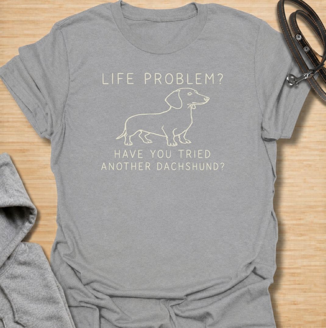 A funny dachshund T-shirt for anyone who believes most problems could probably be improved by adding another sausage dog. Featuring the phrase “Life Problem? Have You Tried Another Dachshund?” with a simple line-art dachshund, this design delivers dry breed-specific humor in a clean, easy-to-wear style. Perfect for dachshund moms, dachshund dads, multi-dog households, and anyone always tempted to bring home one more doxie. A playful everyday tee for fans of dachshund humor, wiener dogs, and funny dog