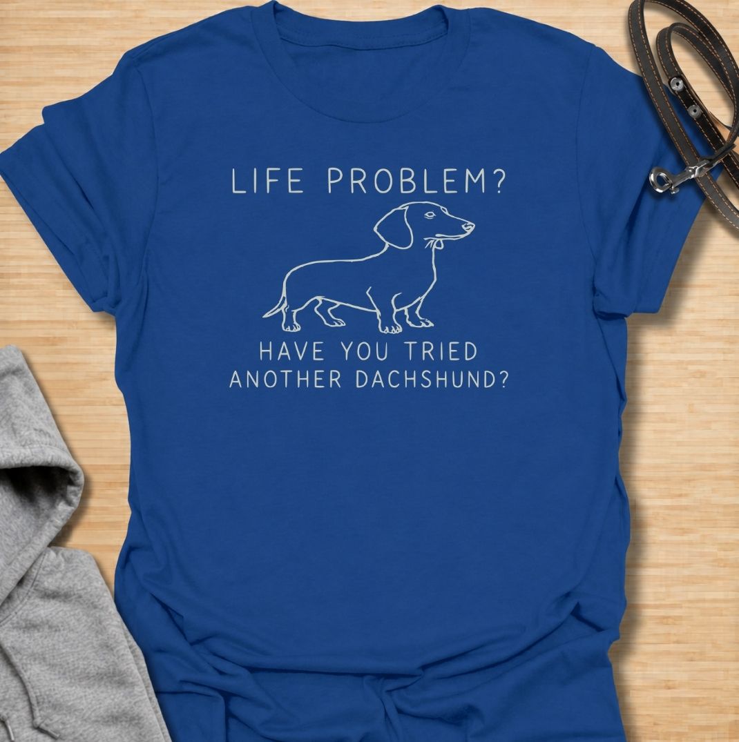 A funny dachshund T-shirt for anyone who believes most problems could probably be improved by adding another sausage dog. Featuring the phrase “Life Problem? Have You Tried Another Dachshund?” with a simple line-art dachshund, this design delivers dry breed-specific humor in a clean, easy-to-wear style. Perfect for dachshund moms, dachshund dads, multi-dog households, and anyone always tempted to bring home one more doxie. A playful everyday tee for fans of dachshund humor, wiener dogs, and funny dog